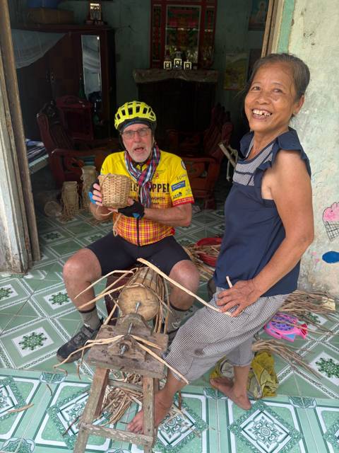       Visitor learns traditional basket weaving from a local artisan inside a rural home.
  