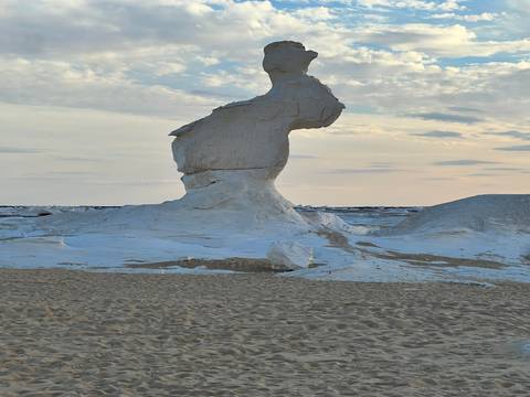       Close-up of a striking white rock pillar shaped by wind erosion rising from the desert floor.
  