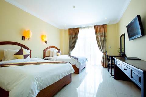       Bright hotel twin room with crisp white bedding and sunlight streaming through sheer curtains.
  