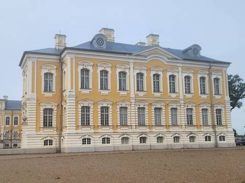       Elegant yellow Baroque palace with white pilasters and tall windows.
  