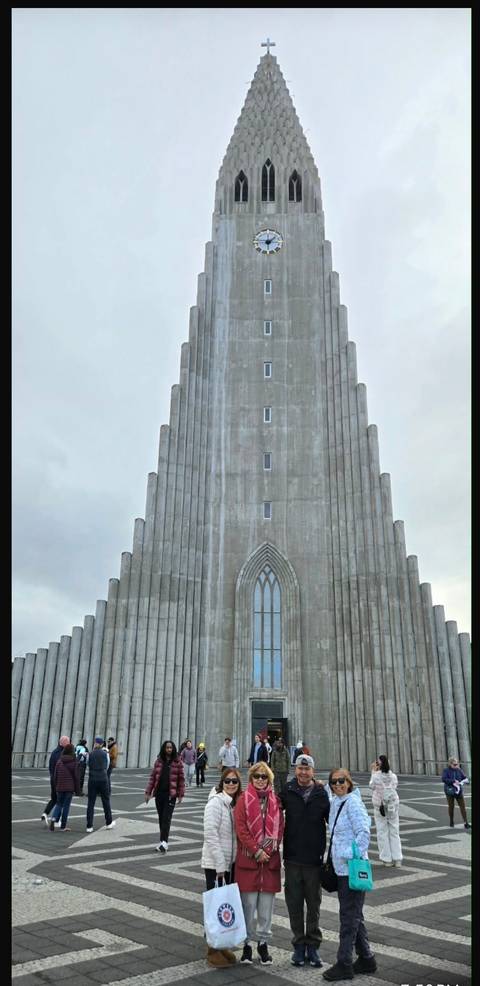       Front view of the tall concrete Hallgrímskirkja church against a grey sky.
  
