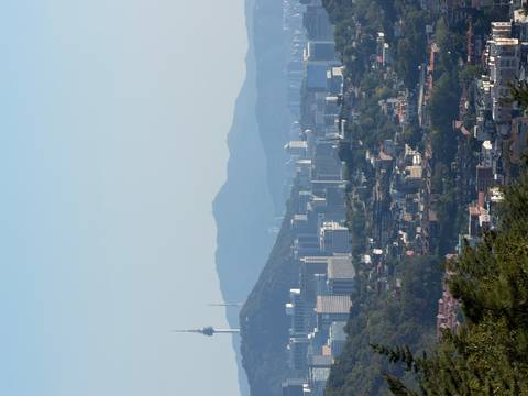       Wide Seoul cityscape with mountains and Namsan Tower visible under clear sky.
  