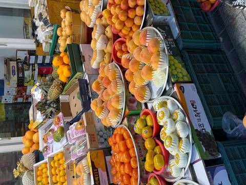       Market display of neatly arranged peaches, mandarins and other fresh fruit.
  
