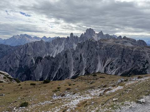       Dramatic grey limestone pinnacles of the Dolomites under a moody cloud-filled sky.
  