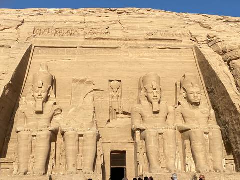       Impressive rock-cut statues of Ramesses II at Abu Simbel Temple bathed in warm sunlight.
  