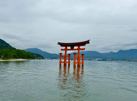       Iconic floating torii gate of Itsukushima Shrine standing in calm water.
  