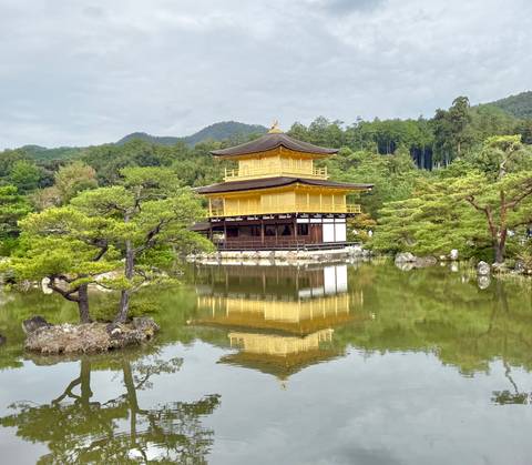       Golden Pavilion (Kinkaku-ji) reflected perfectly in a tranquil pond surrounded by greenery.
  