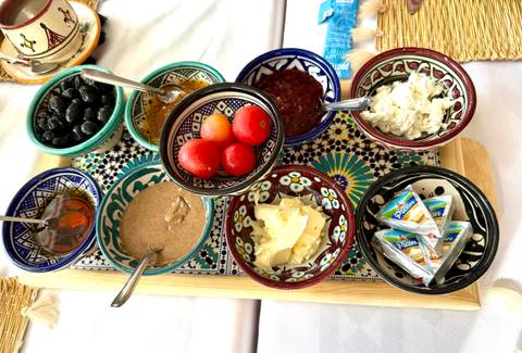       Traditional Moroccan breakfast spread with colorful ceramic bowls of jams, cheese, olives and honey.
  