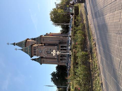       Grand Orthodox cathedral with ornate spires and patterned brickwork against a clear sky.
  
