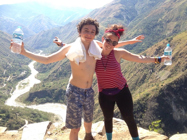       Two people posing on a scenic mountain trail.
  