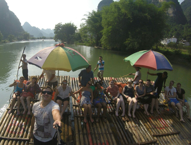 Group on a bamboo raft in a river setting.