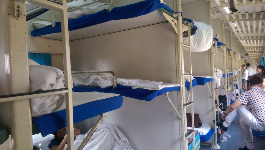 Interior of a train with sleeper bunks.