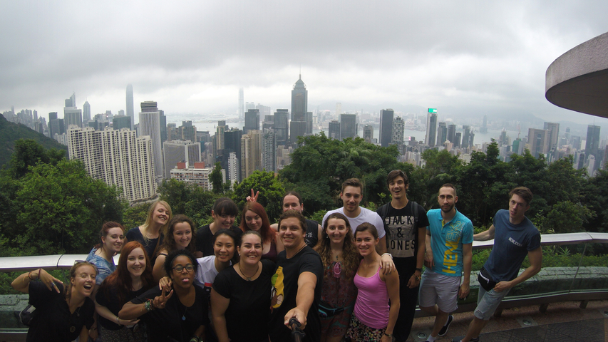 Group selfie with a city skyline in the background.