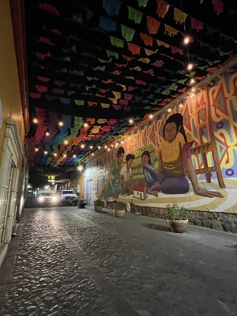 Tilted image of colorful mural decorations with lights at night.