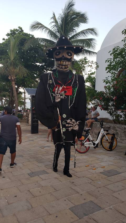 Person in skeleton costume on a street.
