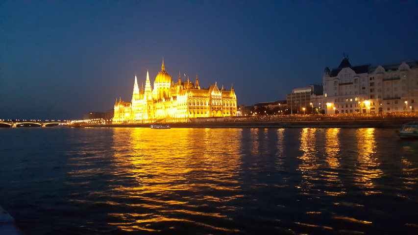 Illuminated building by a river at night.