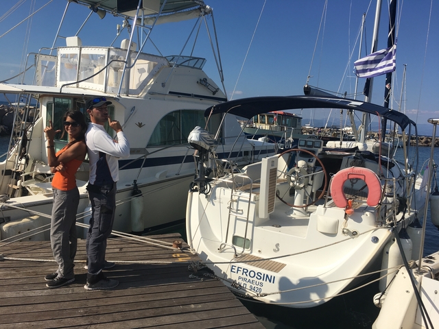       Couple posing with a sailboat in a marina.
  