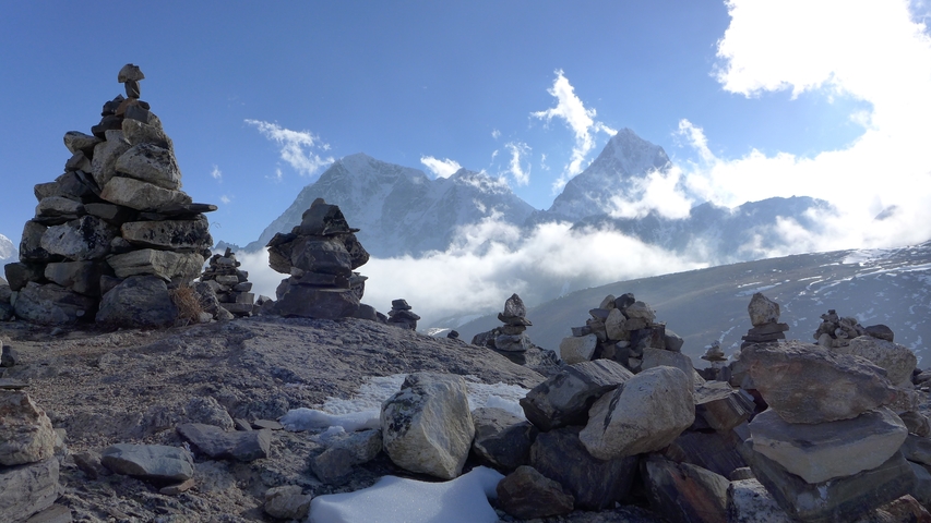       Cairns in a mountainous area beneath a blue sky.
  