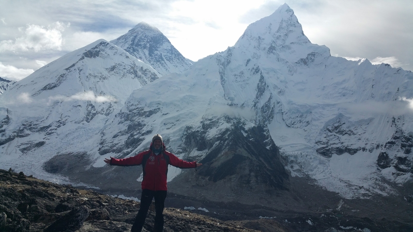       Person posing in front of snowy mountainous landscape.
  