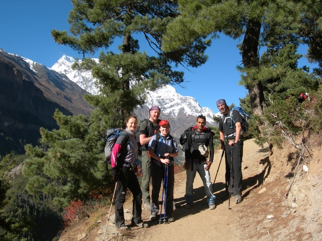 Hiking group posing in front of snowy peaks.