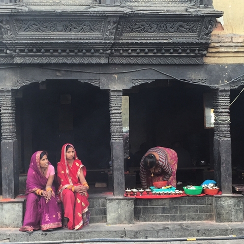 Traditional building with people in colorful attire.