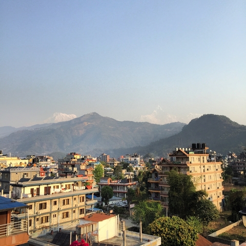       Panoramic view of a city with mountains in the background.
  