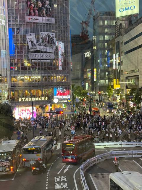 Crowded street scene in Shibuya, Tokyo, with renowned crossing and neon lights.