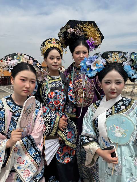 Group of people in traditional Chinese attire posing for a photo.