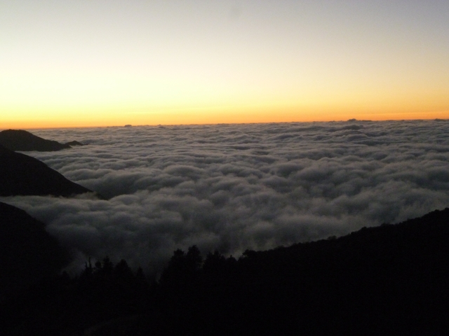       Clouds over a mountain range at sunset.
  