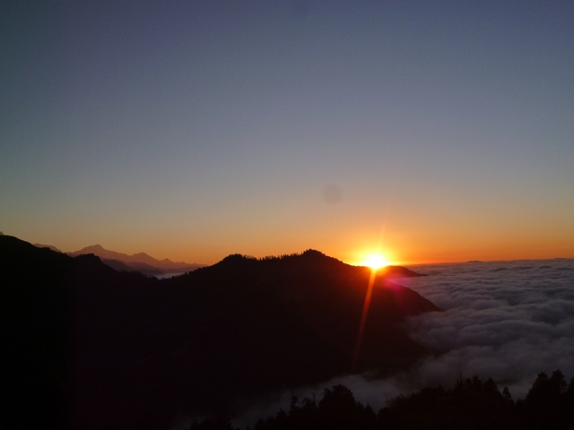      Sunrise over mountains and a sea of clouds.
  