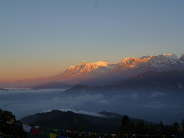       Mountain range with a layer of clouds at dawn.
  