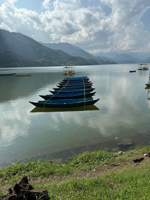 Colorful boats on a calm lake with mountains in the background