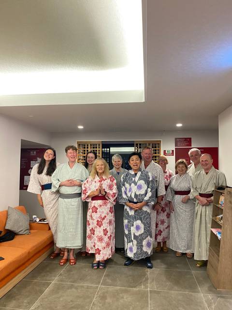       Group of people wearing traditional robes indoors.
  