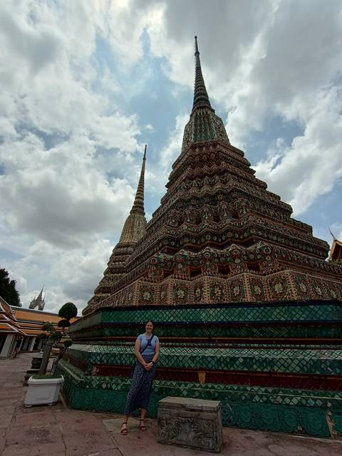       Functional temple with colorful intricate design, person posing nearby.
  