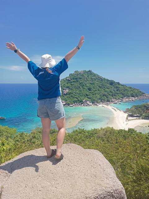       Person at a scenic viewpoint overlooking beaches and clear waters.
  