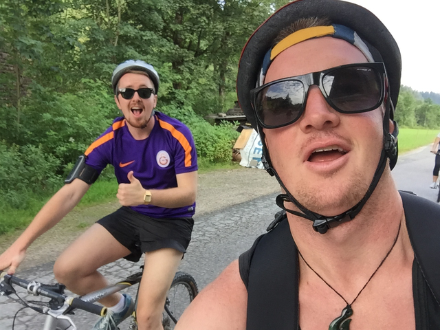 Two people biking on a path surrounded by nature.