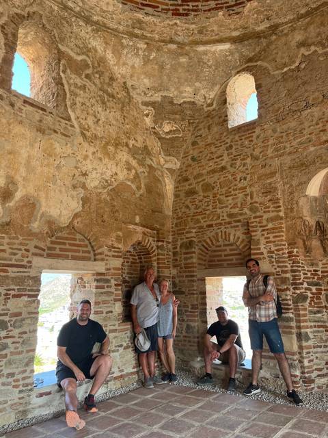 A group of people sitting in an old stone building.