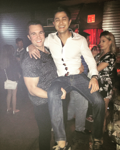 Two people posing at a social event indoors.