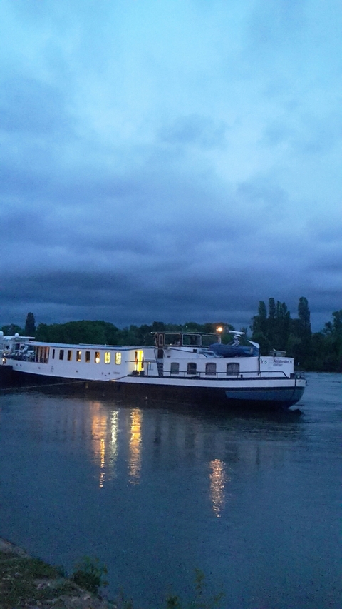 Boat on water under a cloudy night sky.