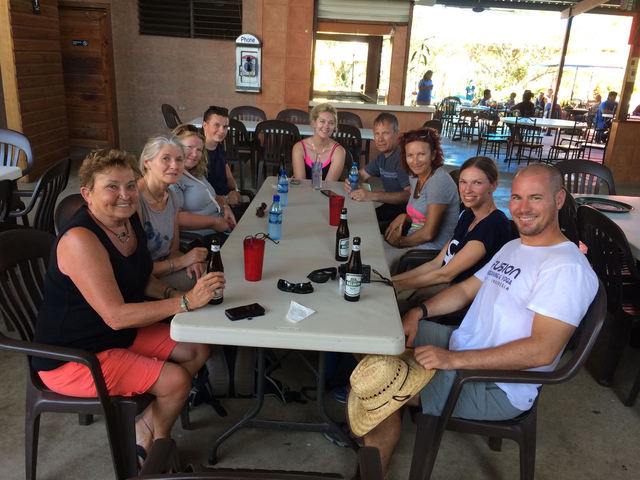 Group of people sitting around a table outdoors.
