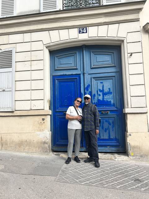       Two people standing in front of a blue door.
  