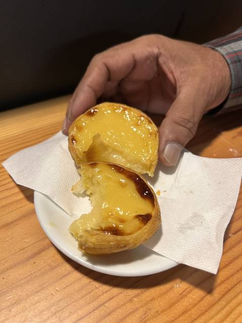 Custard tart being held.