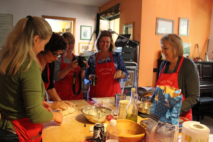 Group of women cooking together in a kitchen.