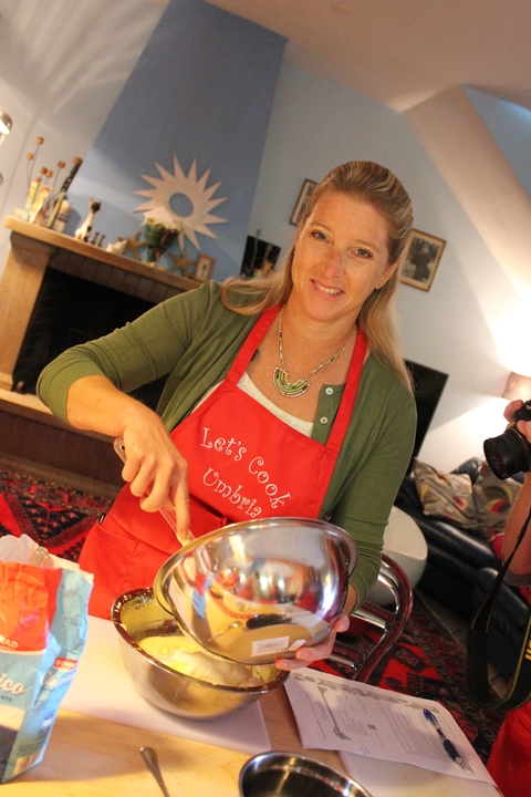 Woman smiling while cooking in a kitchen.