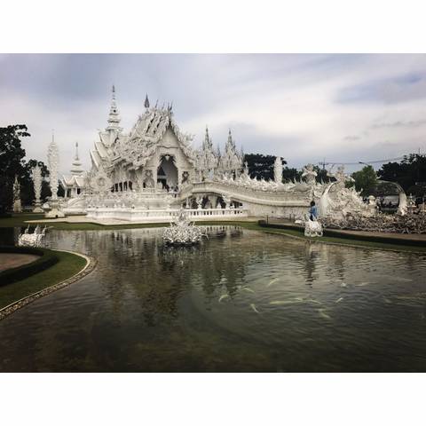       The intricate White Temple with reflections in a pond.
  
