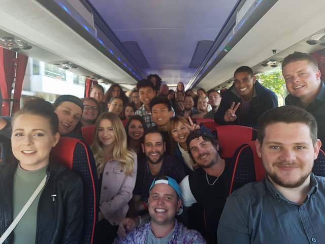 Large group of people smiling and posing inside a bus.