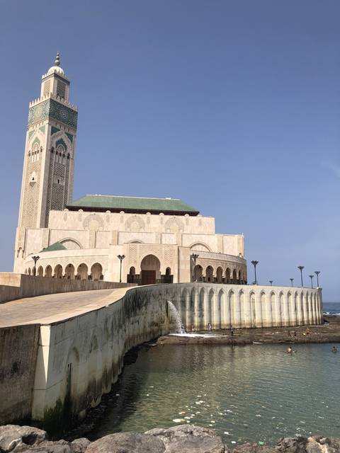       View of a large mosque with fountains in front.
  