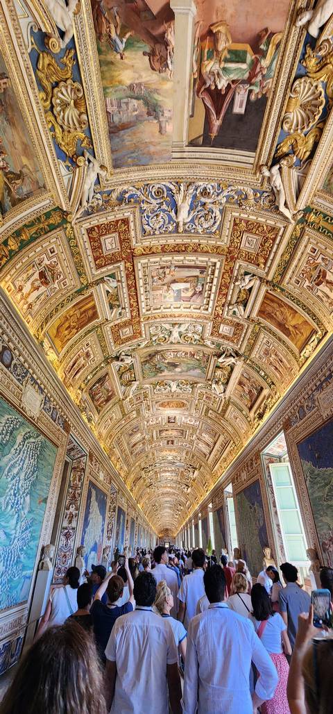       Ornate ceiling with visitors looking.
  