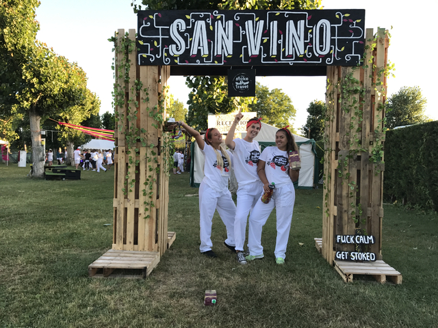       Three women posing at an outdoor entrance.
  