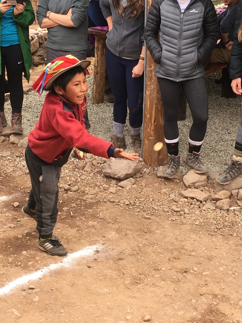 Child playing with others in a rough outdoor area.